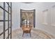 Elegant home foyer featuring tile floors, a decorative table with candles, and an arched stone accent wall at 28503 N 104Th Way, Scottsdale, AZ 85262