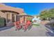 Outdoor dining area with a cozy stone fireplace, ideal for enjoying meals in a serene outdoor setting at 28503 N 104Th Way, Scottsdale, AZ 85262