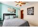 This bedroom includes a ceiling fan and a calming color theme with unique wall art at 2868 E Dunbar Dr, Phoenix, AZ 85042