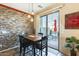 Dining area with stone accent wall, a dark wood table and chairs, and sliding door access to patio at 2868 E Dunbar Dr, Phoenix, AZ 85042