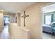 Neutral hallway features views into bedrooms plus decorative metal cross on the wall at 2868 E Dunbar Dr, Phoenix, AZ 85042