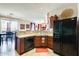 Kitchen with wood cabinets, a black refrigerator, and access to dining area and living spaces at 2868 E Dunbar Dr, Phoenix, AZ 85042