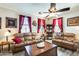 Cozy living room with wood-look flooring, leather sofas, decorative accents, and bright natural light at 2868 E Dunbar Dr, Phoenix, AZ 85042