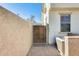 A walkway to the side yard with stucco walls, a locked gate and brick flooring at 2868 E Dunbar Dr, Phoenix, AZ 85042