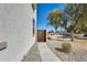 Pathway beside the home with a wooden gate, leading to a green space beyond the yard at 2868 E Dunbar Dr, Phoenix, AZ 85042