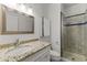 Bathroom with granite countertop, white cabinets, and tiled shower with glass door at 302 W Stella Ln, Phoenix, AZ 85013