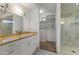 Bright bathroom with a granite countertop, white cabinetry, and a marble tiled shower at 302 W Stella Ln, Phoenix, AZ 85013