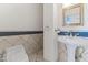 Powder room with pedestal sink and tiled accent wall, providing an elegant and functional space at 302 W Stella Ln, Phoenix, AZ 85013