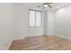 Neutral bedroom features hardwood floors, white walls, and large window at 302 W Stella Ln, Phoenix, AZ 85013