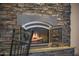 Close-up of stone fireplace with hearth and fire burning at 302 W Stella Ln, Phoenix, AZ 85013