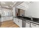 Open kitchen with white cabinets, stainless appliances, black countertops and wood floors at 302 W Stella Ln, Phoenix, AZ 85013