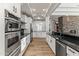 Spacious kitchen featuring stainless steel appliances, white cabinetry, hardwood floors, and black countertops at 302 W Stella Ln, Phoenix, AZ 85013