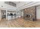 Open-concept living room with a stone fireplace, hardwood floors, and a kitchen with modern appliances at 302 W Stella Ln, Phoenix, AZ 85013