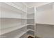 Bright walk-in closet with custom white shelves and corner shelving at 302 W Stella Ln, Phoenix, AZ 85013