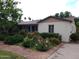 Charming single-story home featuring a colorful front yard garden with vibrant flowers and lush greenery at 32 E 14Th St, Tempe, AZ 85281