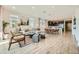 Bright and airy living room flows into dining area and kitchen, featuring wood floors and ample natural light at 38233 N Stillmeadow Rd, San Tan Valley, AZ 85140