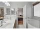 Well-lit bathroom showcasing a soaking tub and double sinks, with a bedroom view at 40265 N Acadia Ct, Anthem, AZ 85086