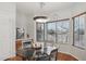 Bright dining area with a glass table, modern lighting, and a view of the neighborhood at 40265 N Acadia Ct, Anthem, AZ 85086