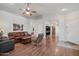 Open concept living room showcasing wood laminate floors, a ceiling fan, and neutral paint colors at 40265 N Acadia Ct, Anthem, AZ 85086