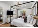 Sun-filled bedroom features a four-poster bed, neutral decor, and a peaceful view from the bright window at 4119 E Indianola Ave, Phoenix, AZ 85018