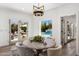 Bright dining room with a view of the pool and an elegant chandelier over the round wooden table at 4119 E Indianola Ave, Phoenix, AZ 85018