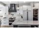 Contemporary kitchen with stainless steel appliances, white cabinetry, and a sleek black range hood at 4119 E Indianola Ave, Phoenix, AZ 85018