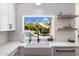 Stylish kitchen sink with a view of the backyard pool and lush greenery through a bright window at 4119 E Indianola Ave, Phoenix, AZ 85018