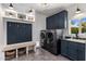 Well-lit laundry room with front load washer and dryer, blue cabinets, and bench seating at 4119 E Indianola Ave, Phoenix, AZ 85018