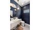 Stylish powder room with floating sink, modern lighting, and blue textured walls at 4119 E Indianola Ave, Phoenix, AZ 85018