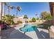 Backyard pool with a basketball hoop, mature palm trees, manicured lawn, and a fenced border at 4502 E Meadow Dr, Phoenix, AZ 85032