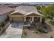 Tan single-Gathering home, aerial view, featuring a two-car garage and a well-maintained, xeriscaped front yard in a residential area at 4708 S 117Th Ave, Avondale, AZ 85323