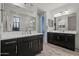 Elegant bathroom featuring dual vanities with dark cabinets and framed mirrors at 4708 S 117Th Ave, Avondale, AZ 85323