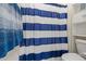 Bathroom featuring a white and blue striped shower curtain and a white toilet at 4708 S 117Th Ave, Avondale, AZ 85323