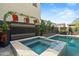 Inviting hot tub with custom tile surround and decorative floral display, next to a refreshing in-ground swimming pool at 4708 S 117Th Ave, Avondale, AZ 85323