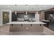 Modern kitchen with large island, pendant lighting, stainless appliances, and dark cabinets at 4708 S 117Th Ave, Avondale, AZ 85323