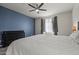 Well-lit bedroom featuring plush carpeting, a ceiling fan, and a large window at 4708 S 117Th Ave, Avondale, AZ 85323