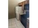 Kitchen with white refrigerator and black microwave and oven next to brown cabinets and tile flooring at 5114 W Joan De Arc Ave, Glendale, AZ 85304