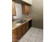 Kitchen with stainless steel sink and black dishwasher next to brown cabinets and tile flooring at 5114 W Joan De Arc Ave, Glendale, AZ 85304