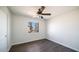 This bedroom features dark hardwood floors, a ceiling fan, and a window with a view at 5327 W Saint Moritz Ln, Glendale, AZ 85306