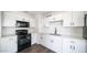 Bright kitchen featuring white shaker cabinets, solid surface counters and black appliances at 5327 W Saint Moritz Ln, Glendale, AZ 85306