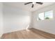 Bright bedroom featuring a ceiling fan, wood floors and a window with a backyard view at 556 E Manor Dr, Casa Grande, AZ 85122