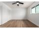 Spacious bedroom featuring wood floors, a ceiling fan and a large window at 556 E Manor Dr, Casa Grande, AZ 85122