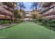 Courtyard putting green lined by multi-story buildings and walkways lined by trees at 7127 E Rancho Vista Dr # 2003, Scottsdale, AZ 85251