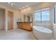 Stylish bathroom featuring a soaking tub, granite vanity, and ample natural light at 7211 E Rising Star Way, Carefree, AZ 85377