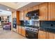 Kitchen featuring wooden cabinets, a Viking range, black countertops, stainless steel backsplash, and modern appliances at 7211 E Rising Star Way, Carefree, AZ 85377