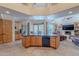 Expansive kitchen featuring a center island with black countertop, wooden cabinetry, and opens up to the adjacent living area at 7211 E Rising Star Way, Carefree, AZ 85377