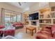 Bright living room with large sliding doors to the patio and comfortable red leather furniture at 7211 E Rising Star Way, Carefree, AZ 85377