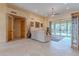 Open living room featuring textured walls, sliding glass doors to the patio, and neutral furniture at 7211 E Rising Star Way, Carefree, AZ 85377