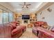 Spacious living room featuring a stone floor, fireplace, and red leather seating arrangement at 7211 E Rising Star Way, Carefree, AZ 85377