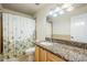 Well-lit bathroom boasting a granite countertop vanity and a shower with a decorative floral curtain at 7629 N Via De La Campana --, Scottsdale, AZ 85258